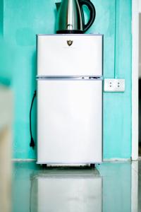 a white refrigerator with a tea kettle on top at Peaceful and Calm place in Lucena