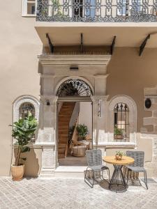 eine Terrasse mit einem Tisch und Stühlen in einem Gebäude in der Unterkunft Casa Modiano Boutique in Chania