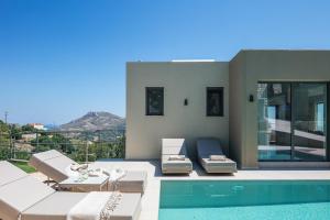 a villa with a swimming pool and patio furniture at Sigma Villa, Private Swimming Pool Garden, Panoramic Sunset in Rethymno Town