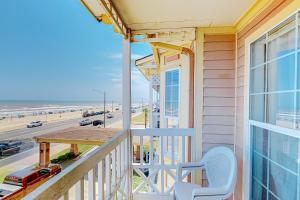 a balcony with a table and a view of the beach at Beachfront Haven in Galveston