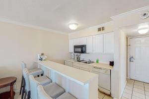a kitchen with white cabinets and a counter top at Beachfront Haven in Galveston