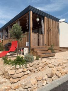 une maison avec une chaise rouge en face dans l'établissement Hollers Holiday Homes Haus Oli, à Drage