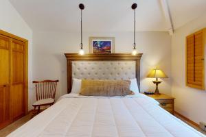 1 dormitorio con 1 cama blanca grande y 1 silla en Brown Bear Lodge #322, en Durango Mountain Resort