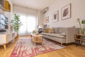 een woonkamer met een bank en een tafel bij Perfect one bedroom apartment in Madrid