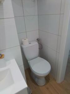a white bathroom with a toilet and a sink at Studio z widokiem na rzekę in Przemyśl
