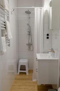 uma casa de banho branca com um lavatório e um chuveiro em Studio z widokiem na rzekę em Przemyśl