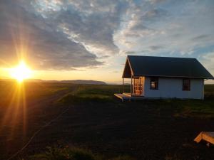 a small house in a field at sunset at Hólar countryside cabin 1 in Selfoss