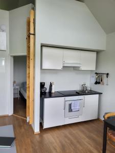 a kitchen with white cabinets and a stove at Hólar countryside cabin 1 in Selfoss