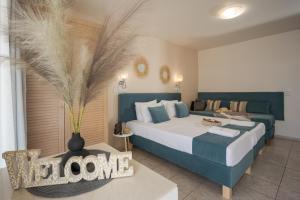 Despina Aparthotel by Philoxenia Hotel & SPA في ماليا: غرفة نوم بسريرين و مزهرية على طاولة