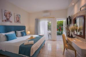 a bedroom with a bed and a desk and a sink at Despina Aparthotel by Philoxenia Hotel & SPA in Malia