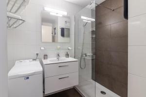 a white bathroom with a sink and a shower at Over the Sea Los Lisos in Las Palmas de Gran Canaria