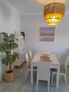 a dining room with a white table and a potted plant at Apartamento Marisma del Guadalquivir in Sanlúcar de Barrameda