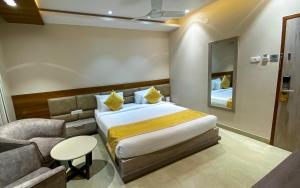 a bedroom with a bed and a chair and a mirror at CENTRAL A BOUTIQUE HOTEL in Belgaum