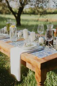 a wooden table with glasses and plates on it at Agriturismo Terra Di Dio Toscanizzazione in Capannoli