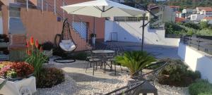 a patio with a table and chairs and an umbrella at Tomena apartments in Trogir