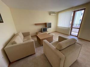 a living room with two couches and a tv at Kavarna Paradise Apartments in Kavarna