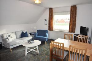 a living room with a couch and a table at Ferienwohnung Bohlen 65265 in Moormerland