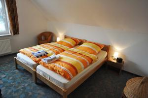 ein Schlafzimmer mit einem großen Bett mit orangefarbenen und gelben Kissen in der Unterkunft Ferienwohnung Bohlen 65265 in Moormerland