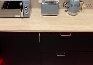a counter top with a wooden counter top with a drawer at Luxury & Spacious 2 Bedroom Flat Families Business Relocation SleeepOva Short Lets & Serviced Accommodation in London