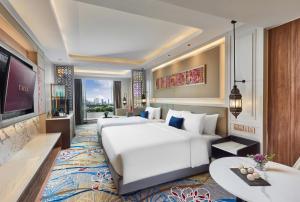 a hotel room with a large bed and a tv at Valia Hotel Bangkok in Bangkok