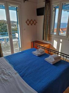 1 dormitorio con 1 cama azul y 2 toallas en Απεραντο Γαλαζιο, en Agia Pelagia - Citera