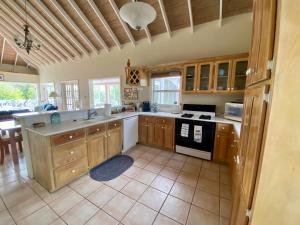 a kitchen with wooden cabinets and a stove top oven at Mandevilla Nevis in Cliftons