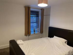 a bedroom with a bed with a window and a phone at Apartment By The Sea! in Morecambe