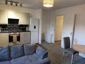 a living room with a couch and a table and a kitchen at Apartment By The Sea! in Morecambe