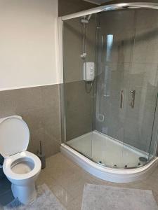a bathroom with a toilet and a glass shower at Apartment By The Sea! in Morecambe
