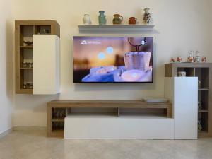 a flat screen tv on a wall in a living room at Happy house in Civitavecchia