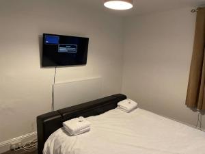 a bedroom with a bed with a tv on the wall at Apartment By The Sea! in Morecambe