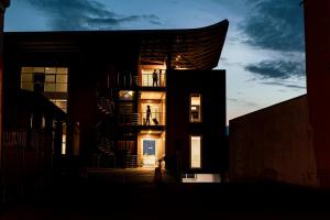 ein Gebäude mit eingeschaltetem Licht am Abend in der Unterkunft Luna Nova Rooms in San Valentino Torio