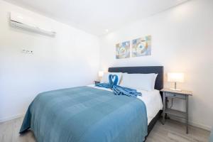 a bedroom with a bed with a blue blanket at The Hub central apartment Burgau in Burgau +17 photos