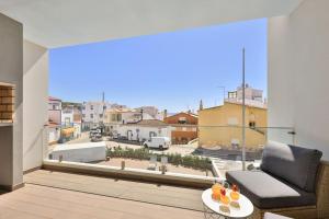 a living room with a couch and a large window at The Hub central apartment Burgau in Burgau