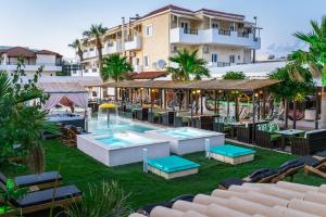 una imagen de un complejo con piscina, mesas y sillas en Despina Aparthotel by Philoxenia Hotel & SPA, en Malia