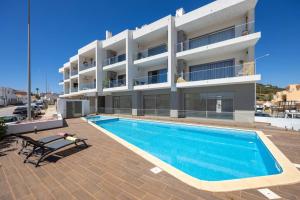 a swimming pool in front of a building at The Hub central apartment Burgau in Burgau