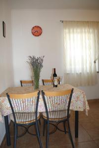 a dining room table with two chairs and a bottle of wine at Apartman Mara in Sveti Juraj