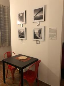 un tavolo con sedie rosse e quadri appesi a un muro di Downtown Lodge Museum a Taranto