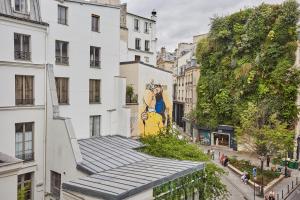 a building with a mural on the side of it at Charming apartment Center of Paris/Montorgueil ( Aboukir 78) in Paris