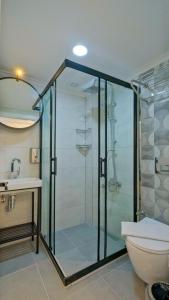uma casa de banho com um chuveiro, um WC e um lavatório. em Miralya Suites em Fethiye