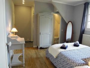Schlafzimmer mit einem Bett, einem Waschbecken und einem Spiegel in der Unterkunft Le Cottage des 3 Pignons in Noisy-sur-École