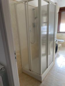 a shower with glass doors in a bathroom at Happy house in Civitavecchia +12 photos