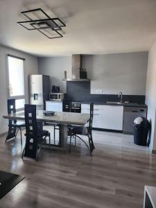 a kitchen with a table and chairs in a room at Appartement sandonato in Clermont-lʼHérault