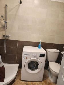 uma casa de banho com um WC e uma máquina de lavar roupa em Appartement sandonato em Clermont-lʼHérault