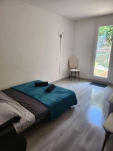 ein Schlafzimmer mit einem Bett, einem Stuhl und einem Fenster in der Unterkunft Appartement sandonato in Clermont-lʼHérault