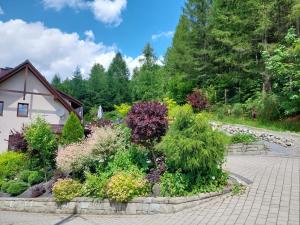 a garden of flowers and plants in front of a house at Apartamenty nad Strumykiem in Brenna