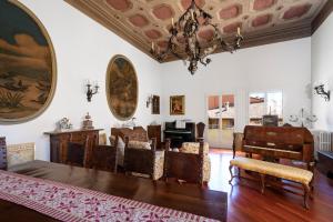 een woonkamer met een kroonluchter en een tafel en stoelen bij Residenza Palazzo Marchesini in Bologna