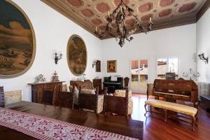 a living room with a chandelier and a table and chairs at Residenza Palazzo Marchesini in Bologna