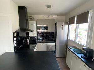 a kitchen with a black counter top at Belle vue de Lognes- 15min Disney/ 5min gare / Parking gratuit in Lognes