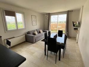 a living room with a couch and a table at Belle vue de Lognes- 15min Disney/ 5min gare / Parking gratuit in Lognes